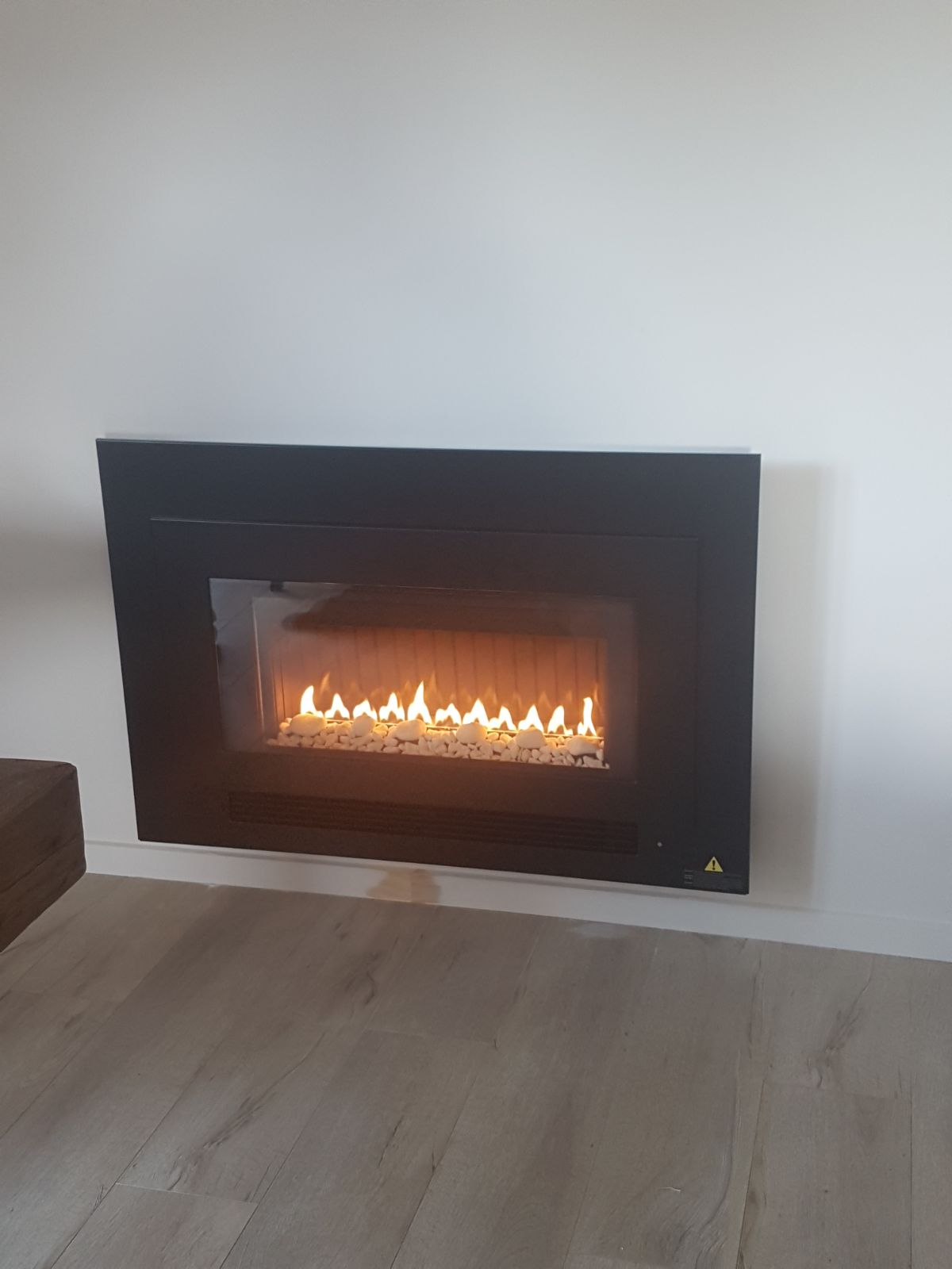 Modern inbuilt gas fire with black frame installed in an Auckland lounge